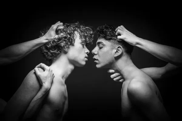 Black and white fine art photography titled Restraint 3 showing two men controlled by external hands in a dark space.